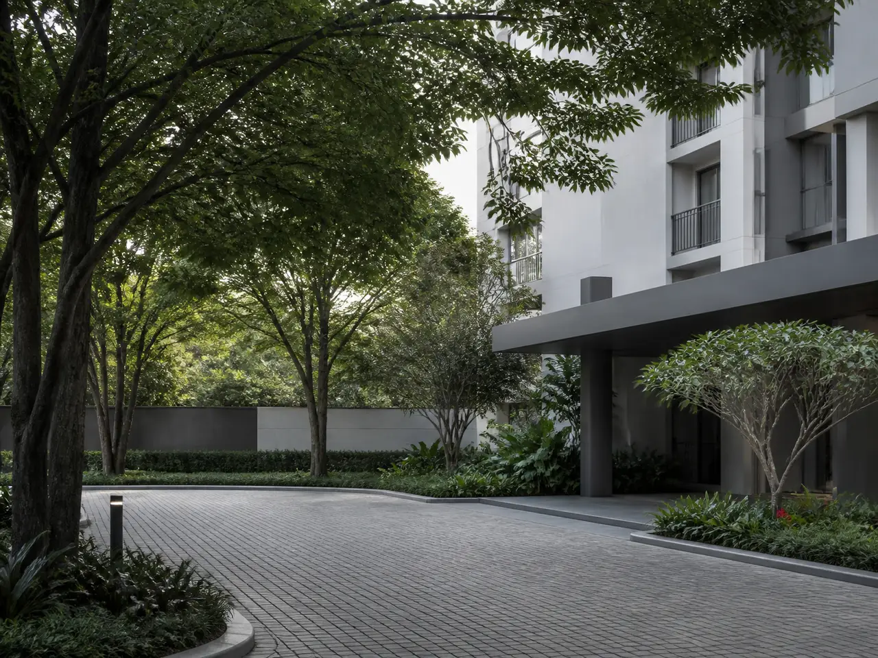 Tree-shaded contemporary residential arrival court with planted edges